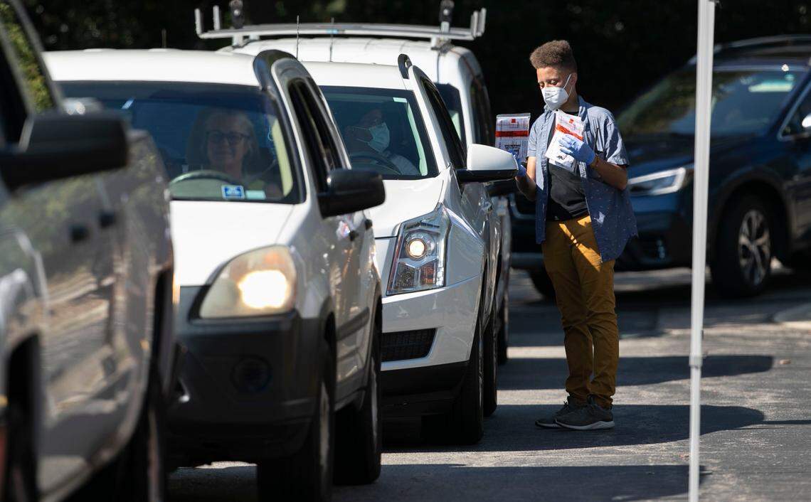 Staff hand out COVID-19 test kits to clients on Departure Drive on Tuesday morning, September 7, 2021 in Raleigh, N.C. Hundreds of people filed into the testing site parking lot on Tuesday morning after being closed for two days for the Labor Day Holiday.