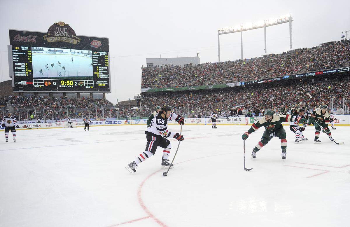 FILE - In this Feb. 21, 2016, file photo, Chicago Blackhawks center Andrew Shaw, left, take a shot on goal past Minnesota Wild center Mikko Koivu during the first period of the NHL Stadium Series hockey game at TCF Bank Stadium, in Minneapolis. The Minnesota Wild, after years of lobbying the league, will finally host the NHL’s signature regular season event next year. The 2021 Winter Classic will coincide with the franchise’s 20th anniversary season.(AP Photo/Craig Lassig, File)