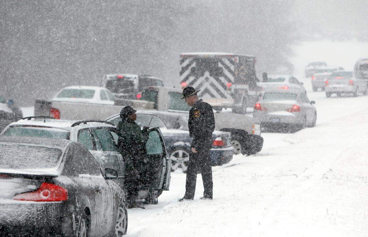 A Highway Patrol officer checks on the well being of a stranded motorist Wednesday, February 11, 2014 on Hammond Road in Raleigh, N.C. as snow pounds the Triangle.