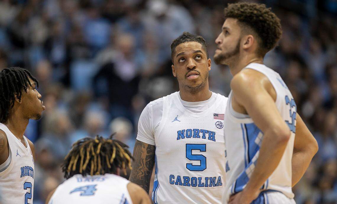 Down by ten points to Miami in the second half, North Carolina’s Armando Bacot (5) and Pete Nance (32) glance at the scoreboards as they huddle with teammates Caleb Love (2) and R.J. Davis (4) during a time out on Monday, February 13, 2023 at the Smith Center in Chapel Hill, N.C.