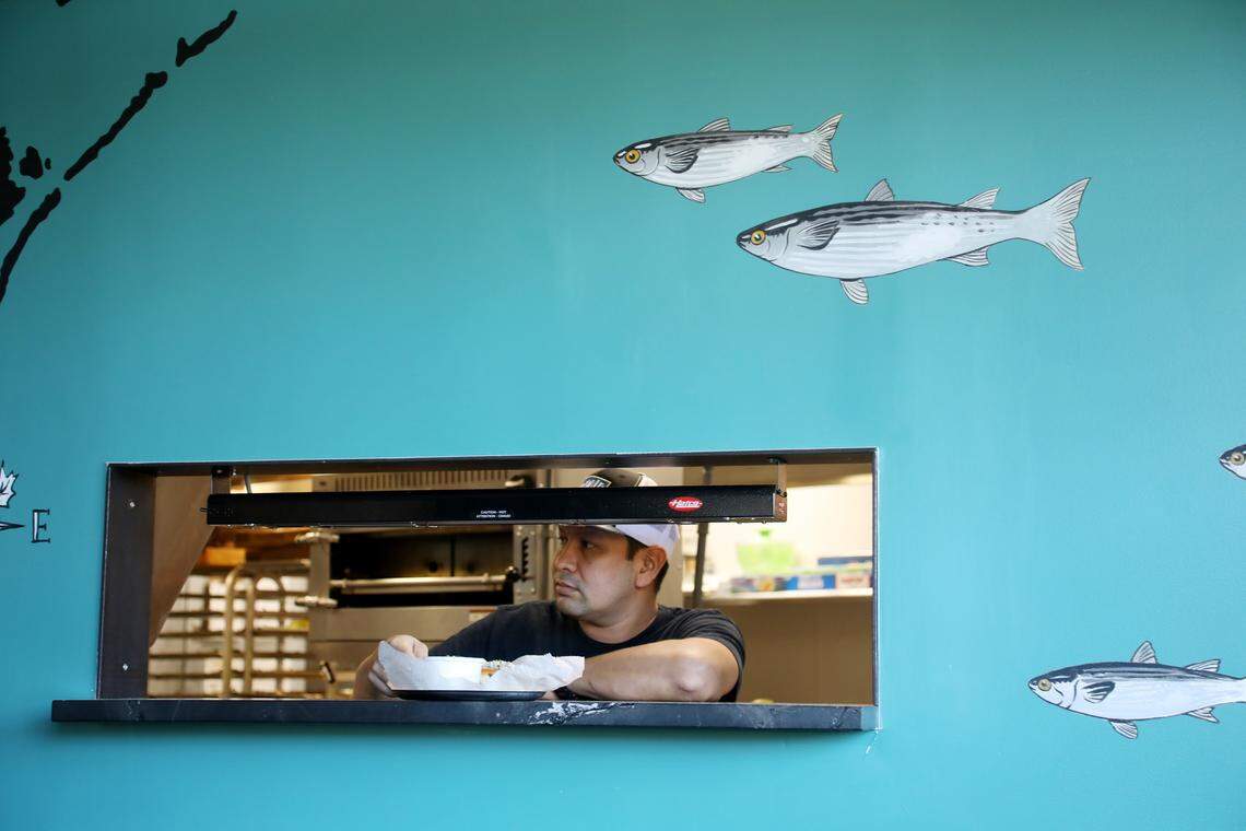 An order comes up in the kitchen window at Locals Oyster Bar on Thursday, Aug. 28, 2019.