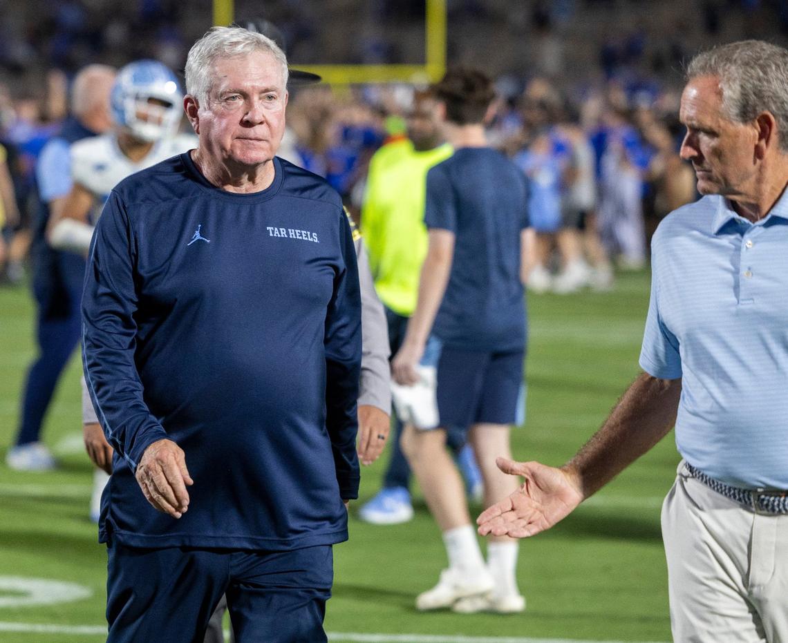 North Carolina Athletic Director Bubba Cunningham offer a handshake to coach Mack Brown following the Tar Heels’ 21-20 loss to Duke on Saturday, September 28, 2024 at Wallace Wade Stadium in Durham, N.C.