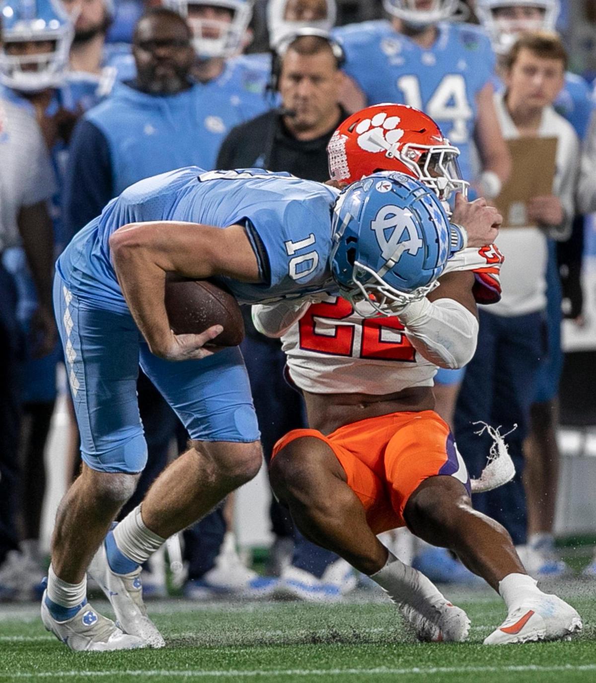 North Carolina quarterback Drake Maye (10) is called for a face make penalty as Clemson’s Trenton Simpson (22) works to stop him in the second quarter during the ACC Championship game on Saturday, December 3, 2022 at Bank of American Stadium in Charlotte, N.C.