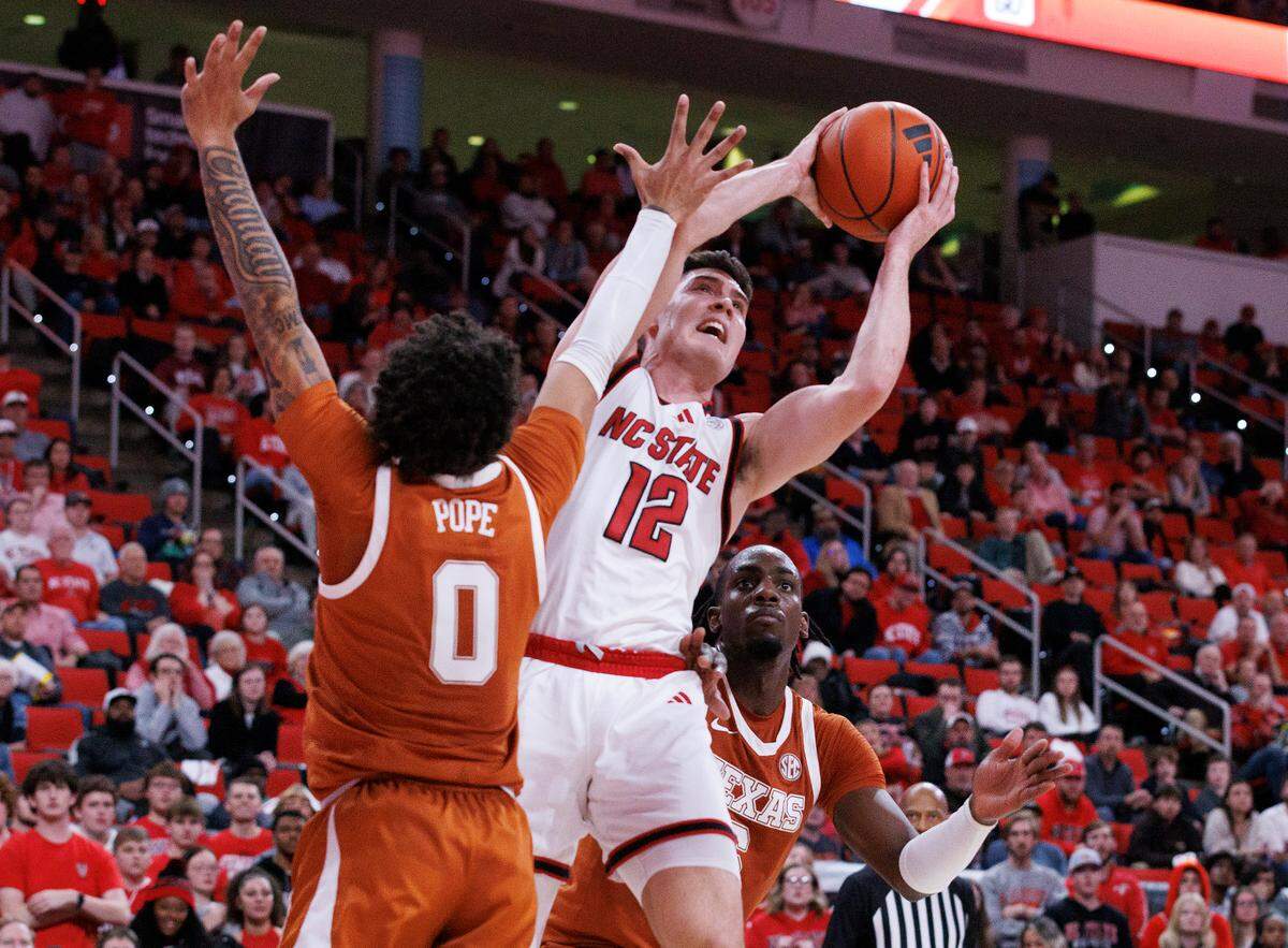 N.C. State’s Michael O’Connell shoots over Texas’ Jordan Pope during the second half of the Wolfpack’s 63-59 loss on Wednesday, Dec. 4, 2024, at Lenovo Center in Raleigh, N.C.