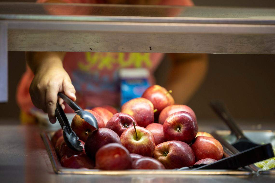 A student selects an apple in the lunch line at Kingswood Elementary in Cary on June 4, 2024. Higher food costs and employee salaries are contributing to a budget shortfall for the Wake County school system.