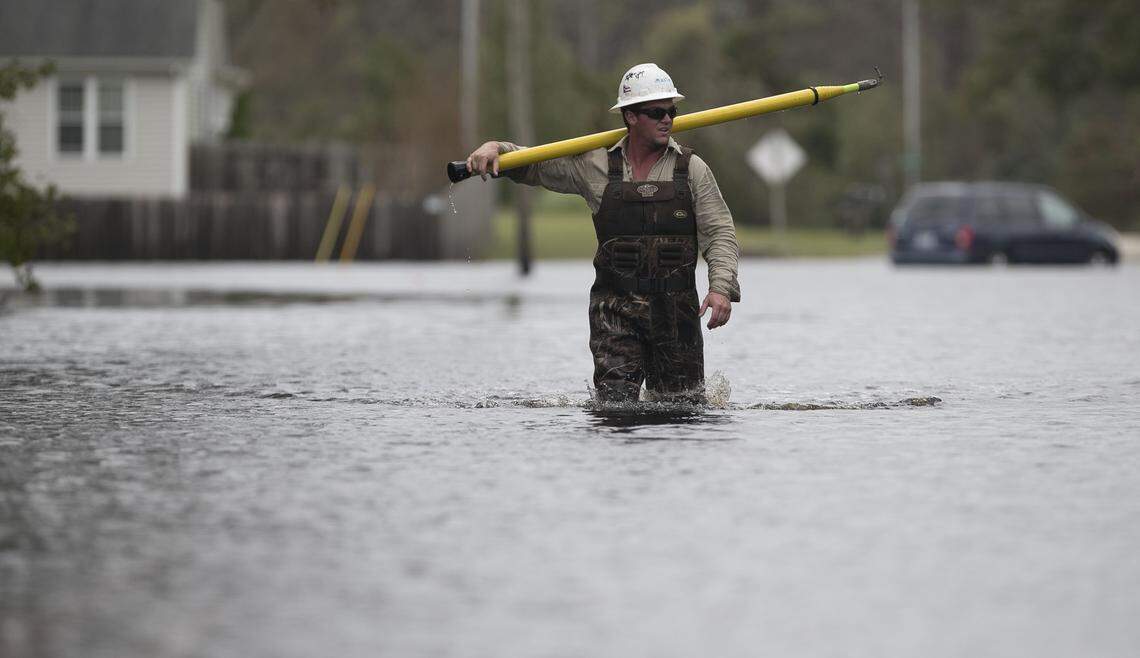 Mastec employee John Chadwick walks out of waist deep water after working to restore part of the power grid off of Nine Foot Road in Newport, N.C. on Sunday, September 16, 2018. Most of the Carteret County town is without power after Hurricane Florence moved across the area. 