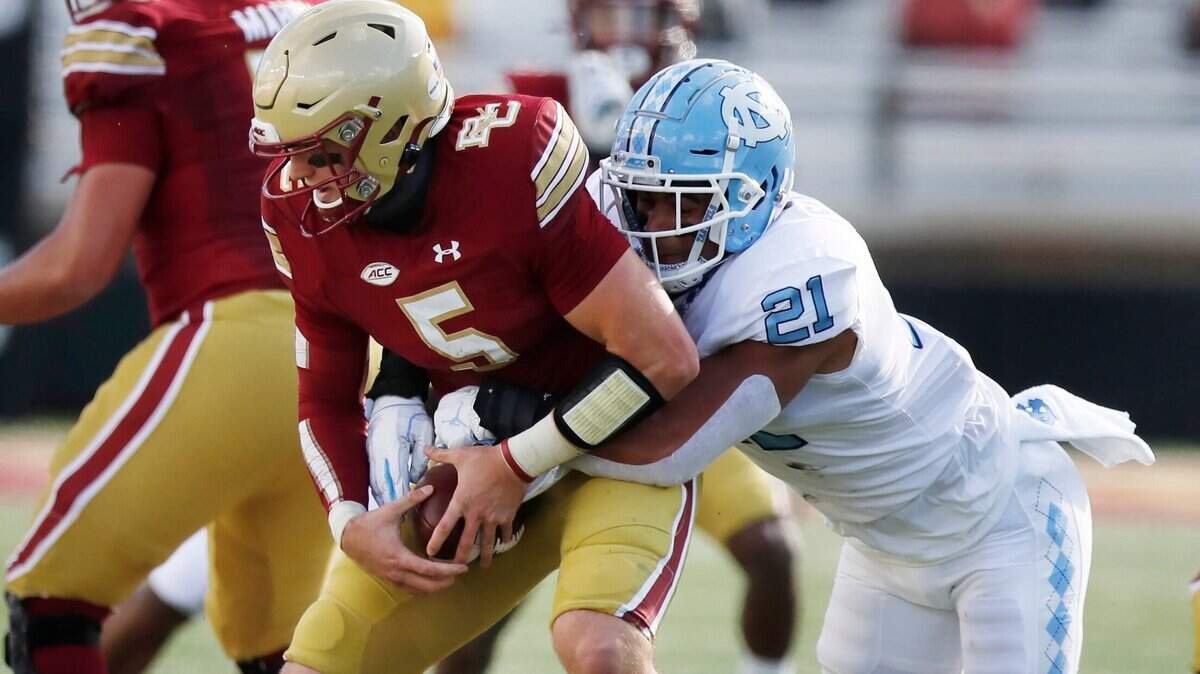 North Carolina linebacker Chazz Surratt (21) tries to strip the ball from Boston College quarterback Phil Jurkovec (5) during the first half of an NCAA college football game, Saturday, Oct. 3, 2020, in Boston.