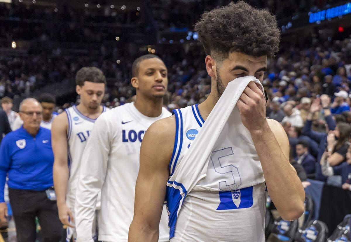 Duke guard Cayden Boozer (2) covers his face as he leaves the court with his teammates after falling to Connecticut 73-72 on Sunday, March 29, 2026, in the NCAA East Regional Championship, at Capital One Arena in Washington, D.C