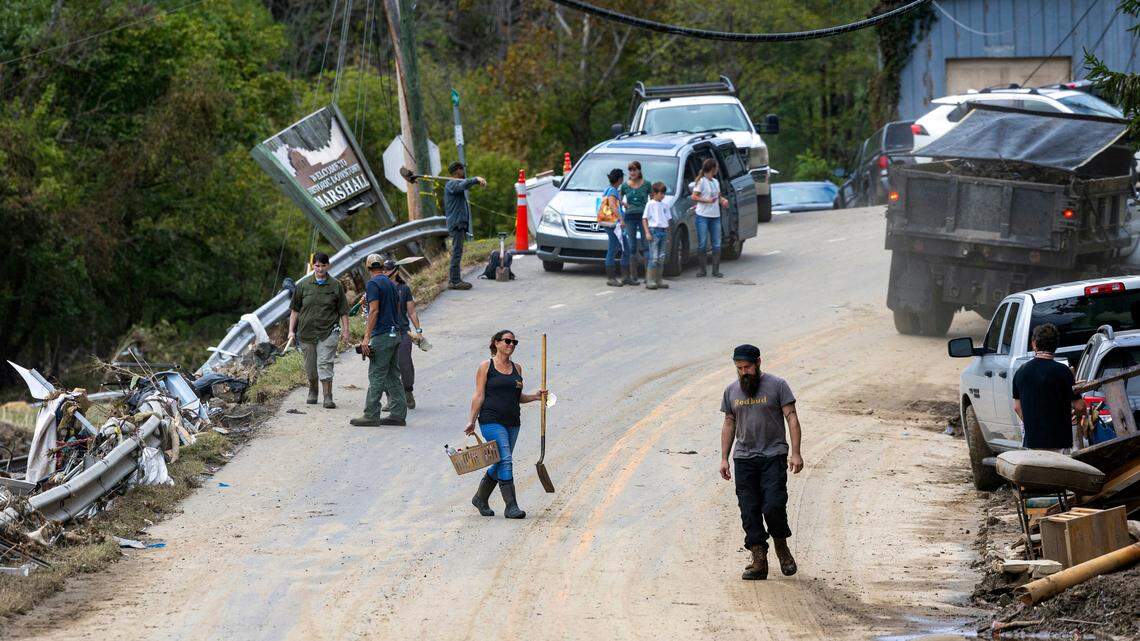 Residents and volunteers clean up on Tuesday, Oct. 1, 2024 after the French Broad River flooded downtown Marshall. The remnants of Hurricane Helene caused widespread flooding, downed trees, and power outages in western North Carolina.