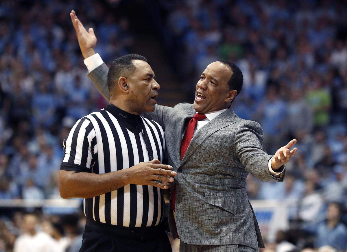 N.C. State head coach Kevin Keatts talks with official Jeff Clark during the first half of N.C. State’s game against UNC at the Smith Center in Chapel Hill, N.C. Tuesday, Feb. 5, 2019.