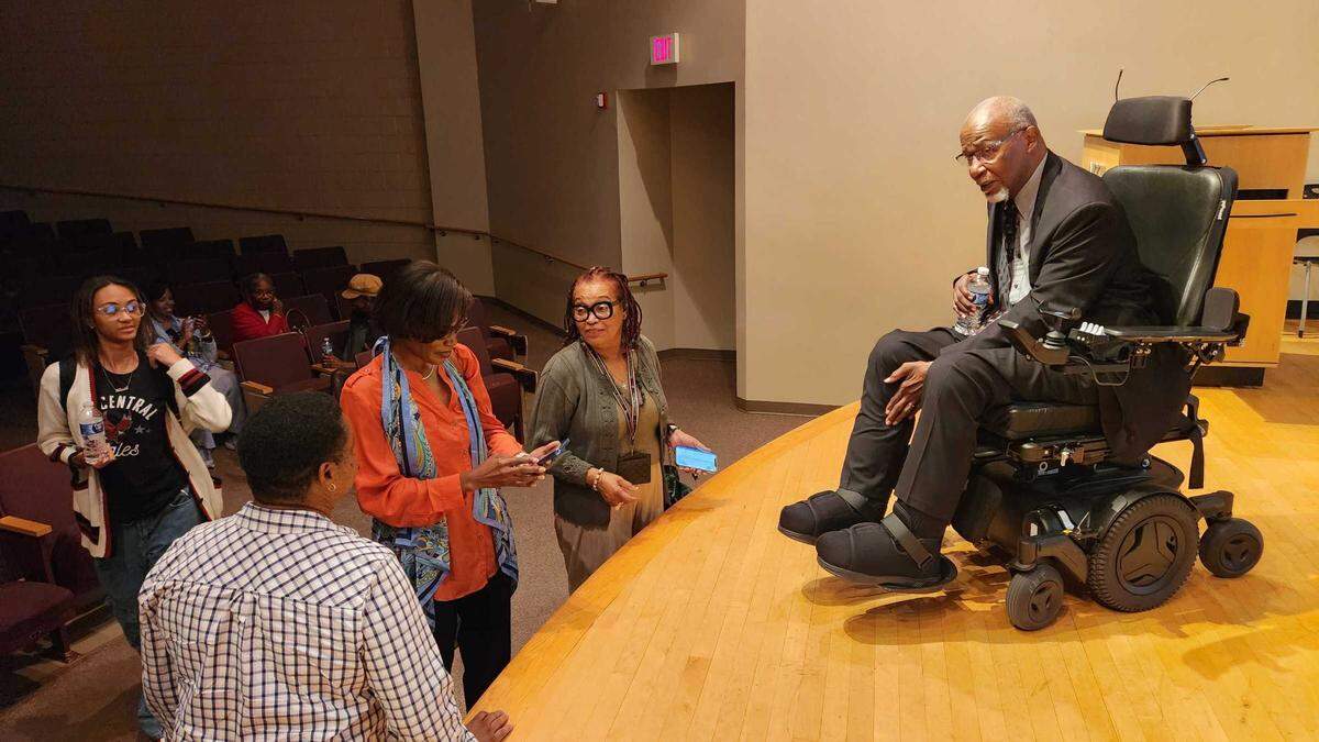 N.C. Central University political science professor Jarvis Hall, on stage, talks with members of the audience after a News & Observer Under the Dome: Live! podcast recording event on Monday, Oct. 21, 2024, in the NCCU School of Education auditorium.
