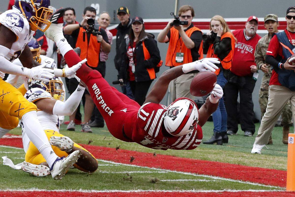 N.C. State wide receiver Jakobi Meyers (11) scores on a 24-yard reception as East Carolina defensive back Warren Saba (17) defends during the first half of N.C. State’s game against East Carolina University at Carter-Finley Stadium in Raleigh, N.C., Saturday, Dec. 1, 2018.