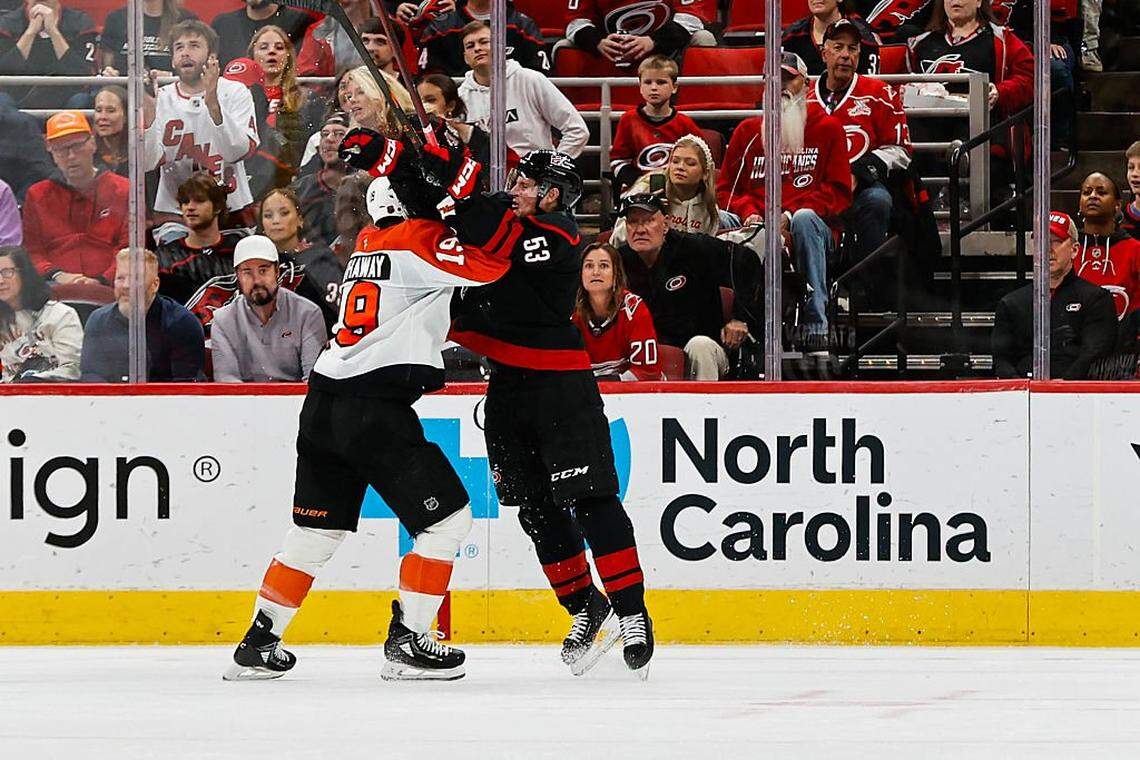 Garnet Hathaway (left) of the Philadelphia Flyers and Jackson Blake of the Carolina Hurricanes vie for the puck during the first period of the game at Lenovo Center on October 11, 2025 in Raleigh, North Carolina.