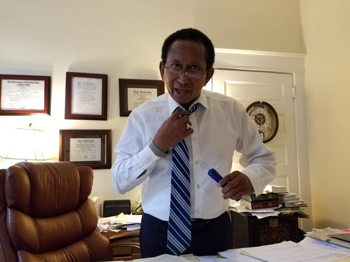 N.C. Sen. Floyd McKissick Jr. (D-Durham) demonstrates how he closes his shirt buttons with a tool he’s needed the past 33 years, since he almost lost his arm after being shot during an armed robbery at the Warren County convenience store he owned.