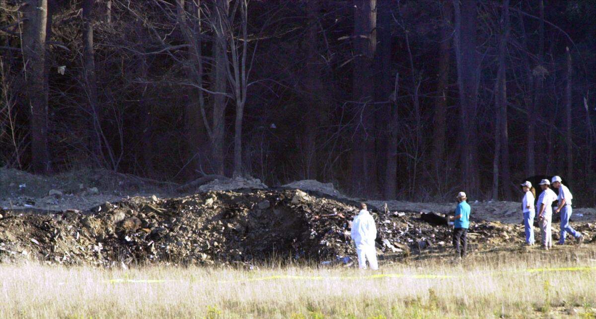 Emergency workers look at the crater created when United Airlines Flight 93 crashed near Shanksville, Pa., in this Sept. 11, 2001 file photo.
