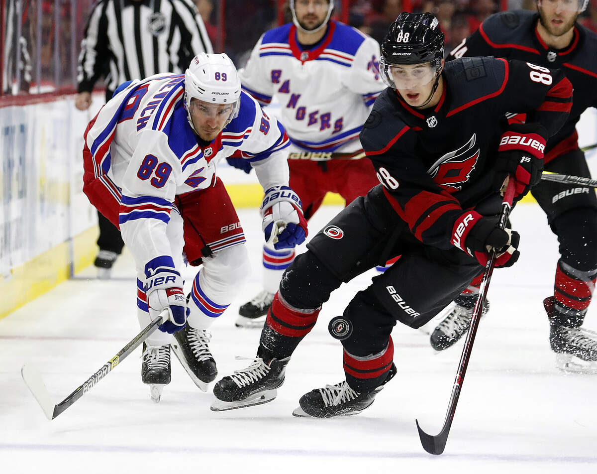 Carolina Hurricanes’ Martin Necas (88) gathers in the puck in front of New York Rangers’ Pavel Buchnevich (89) during the first period of an NHL hockey game, Sunday, Oct. 7, 2018, in Raleigh, N.C. 