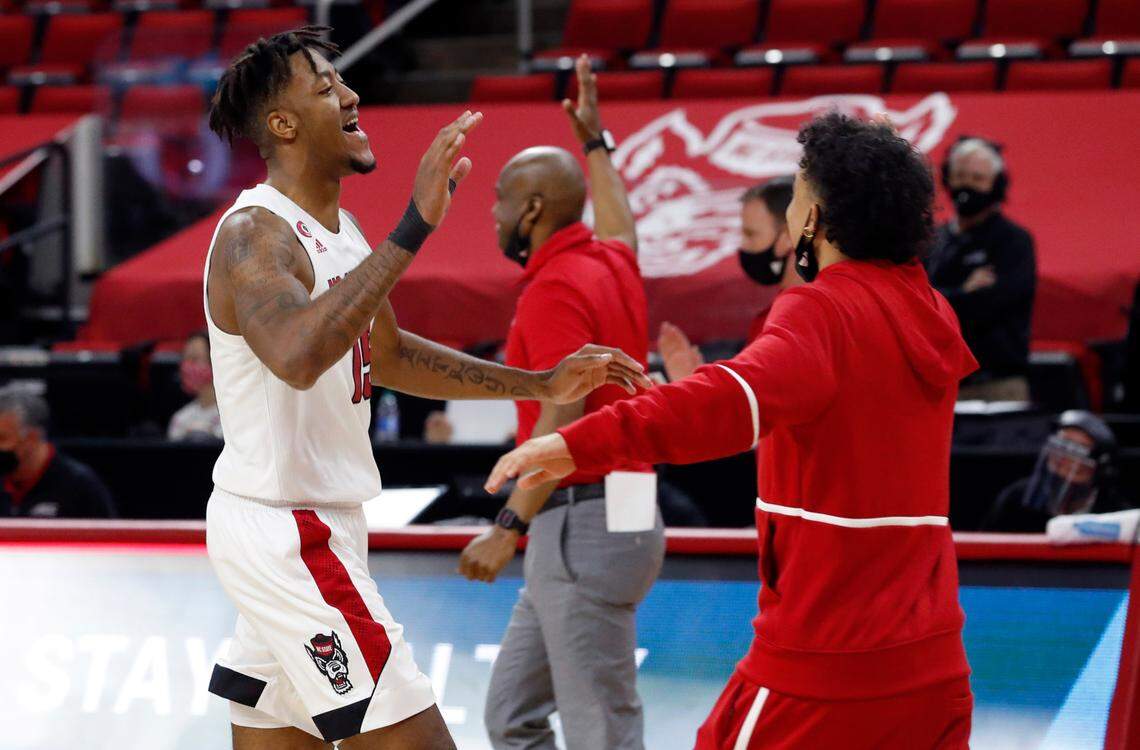 N.C. State’s Manny Bates (15) celebrates with Chase Graham (12) after N.C. State’s 79-76 victory over UNC at PNC Arena in Raleigh, N.C., Tuesday, December 22, 2020.