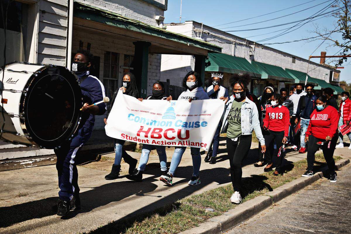Saint Augustine’s University students are led by the marching band to the polls at Tarboro Road Community Center in Raleigh, Tuesday, Nov. 3, 2020.