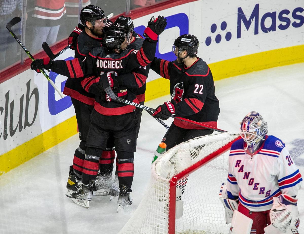 Carolina Hurricanes’ Vincent Trocheck (16) celebrates with Jordan Staal (11), Brady Skjei (76), and Brett Pesce (22) after scoring on New York Rangers goalie Igor Shesterkin (31) to take a 1-0 lead during the first period on Thursday, May 26, 2022 during game five of the Stanley Cup second round at PNC Arena in Raleigh, N.C.
