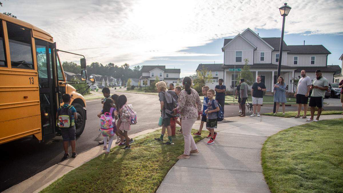 Apex Friendship Elementary School students board a bus on Aug. 29, 2022. Starting in the 2024-25 school year, Wake County students will need to scan a barcode when they enter and exit a school bus.