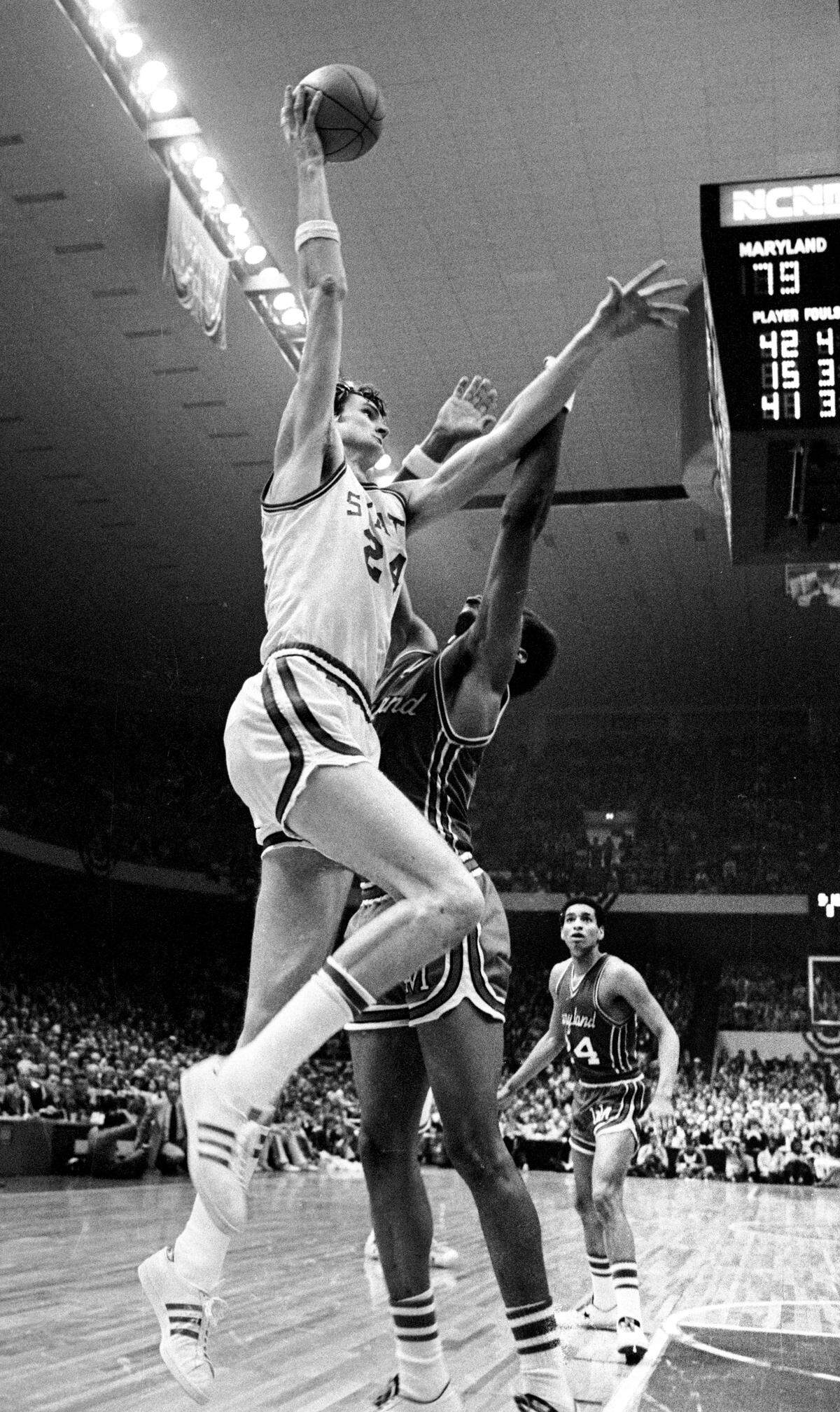 NC State center Tommy Burleson goes up for a shot over Maryland center Len Elmore late in the Wolfpack's ACC Tournament game against Maryland in 1974.  