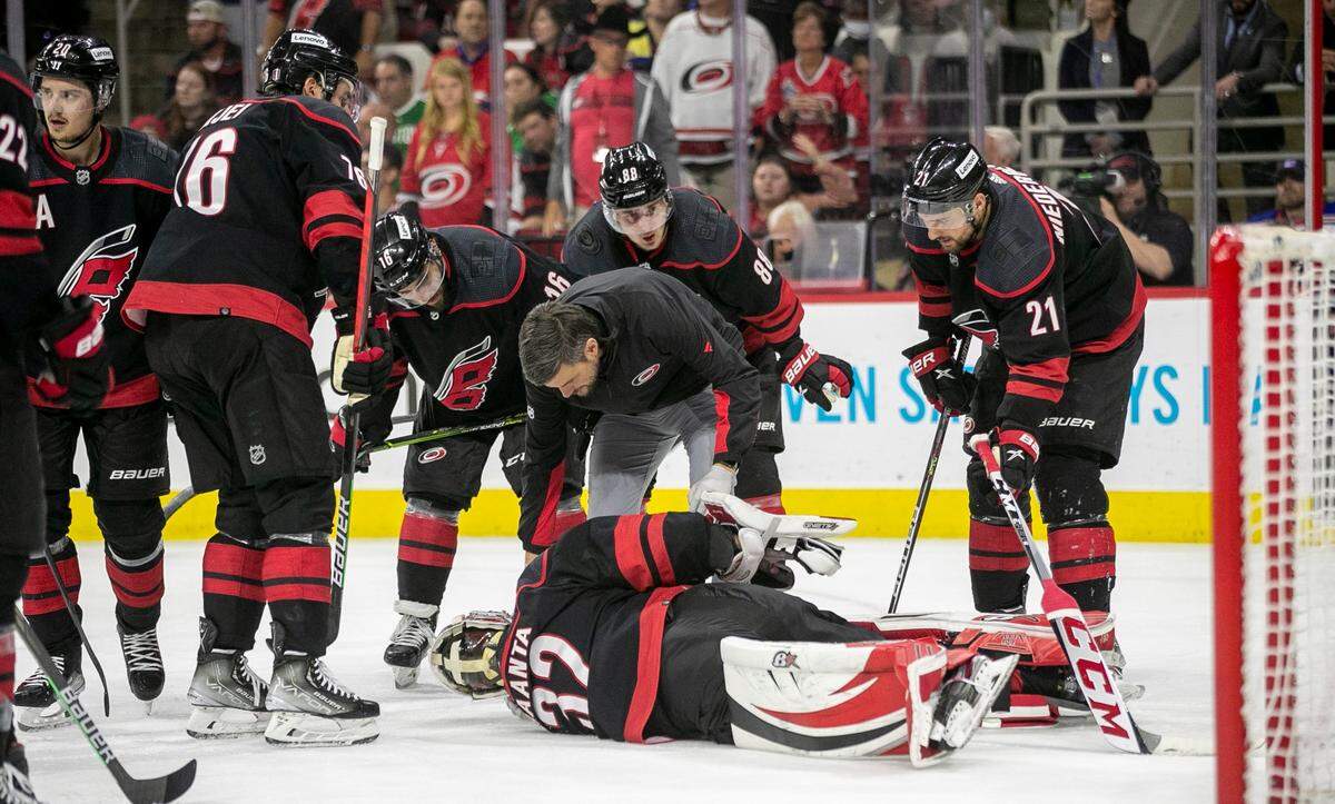Teammates surround Carolina Hurricanes goalie Antii Raanta (32) after the went down with an injury in the second period agains the New York Rangers on Monday, May 30, 2022 during game seven of the Stanley Cup second round at PNC Arena in Raleigh, N.C.