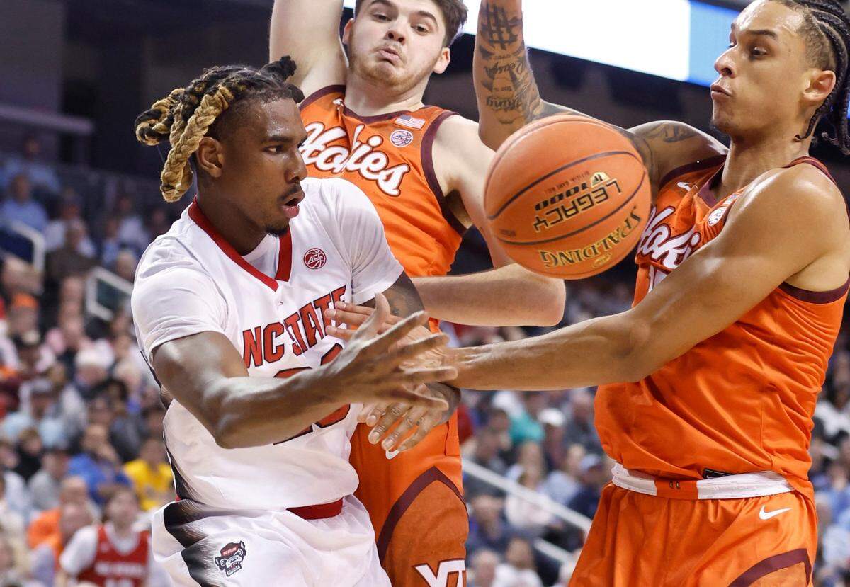 N.C. State’s Greg Gantt (23) passes around Virginia Tech’s Grant Basile (21) and Lynn Kidd (15) during the first half of N.C. State’s game against Virginia Tech in the second round of the ACC Men’s Basketball Tournament in Greensboro, N.C., Wednesday, March 8, 2023.
