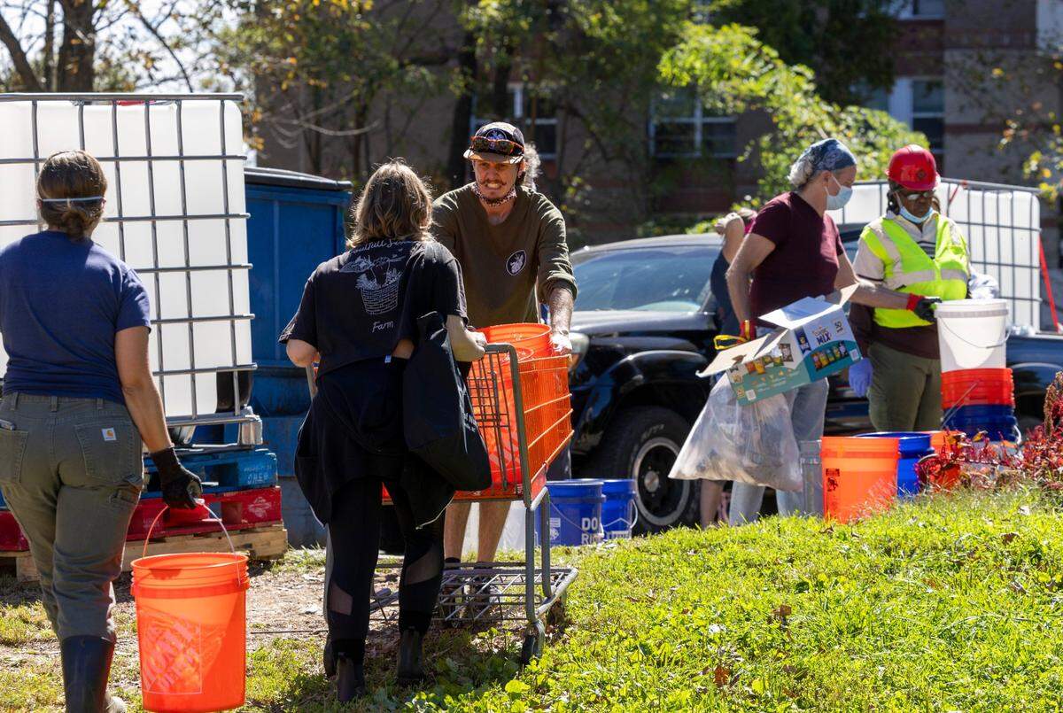 Volunteers organized by grassroots group BeLoved Asheville haul gray water to help residents in low-income independent living facilities, with no running water, flush their toilets on Wednesday, Oct. 9, 2024. About half of Asheville’s water customers were still without running water this week because the remnants of Hurricane Helene ripped apart the city’s distribution system.