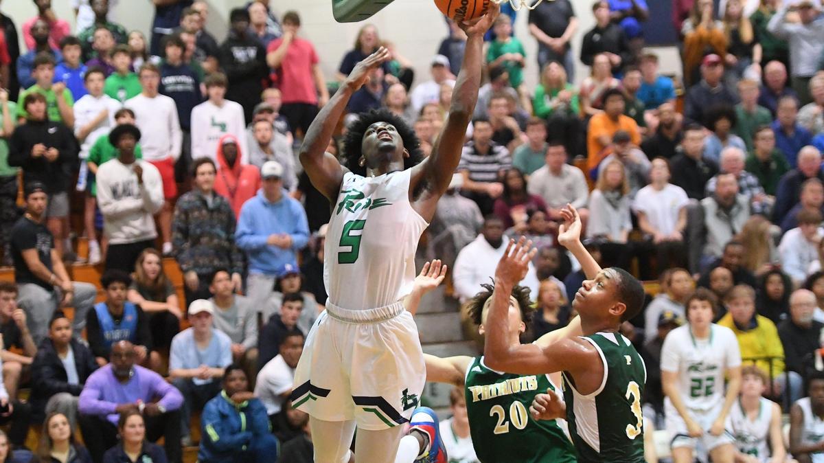 Jalen McDonald (5) of Leesville Road scores with a layup against Bradlee Haskell (3) and Sam Stoltz (20) of Pinecrest. The Pinecrest Patriots visited the Leesville Road Pride in a high school boys basketball game on March 3, 2020.