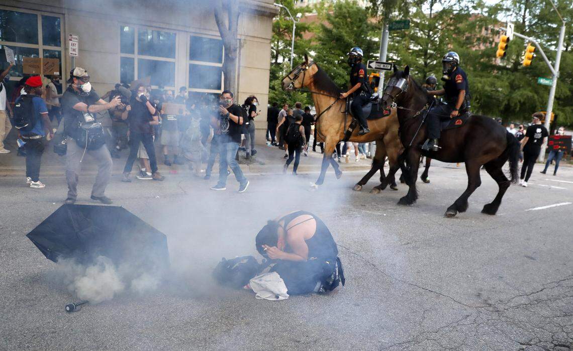 A demonstrators reacts after tear gas was thrown during a protest in downtown Raleigh, N.C. Saturday, May 30, 2020.