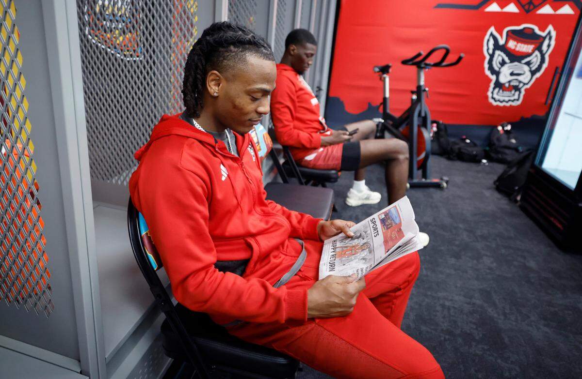 N.C. State’s DJ Horne looks at the Arizona Republic’s sports section before the Wolfpack’s practice at State Farm Stadium in Glendale, Ariz., Friday, April 5, 2024. The Wolfpack will face Purdue in the NCAA Tournament national semifinals Saturday.