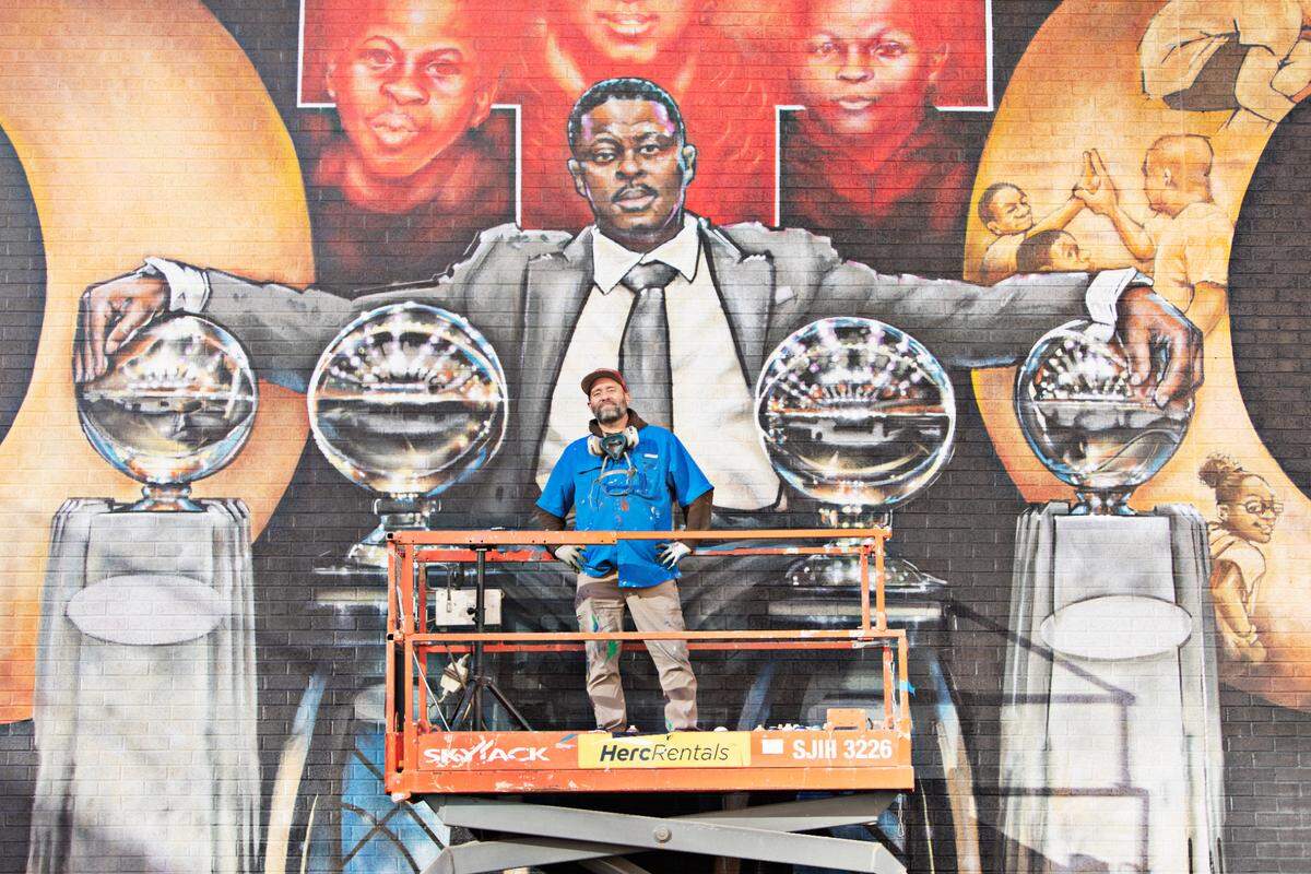 Artist Sean Kernick takes a break from his mural to honor NCCU coach LaVelle Moton on Salibury St. in downtown Raleigh on Tuesday, Nov. 23. 2021.