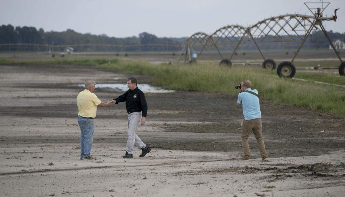 NC Governor Roy Cooper shakes hands with farmer Jimmy Burch in Duplin County near Faison on Friday, Sept.r 21, 2018. Burch lost nearly 1,000 acres of crops, including beets, greens, broccoli and sweet potatoes to flooding from Hurricane Florence. Vegetables were growing last week on the land where they’re standing.
