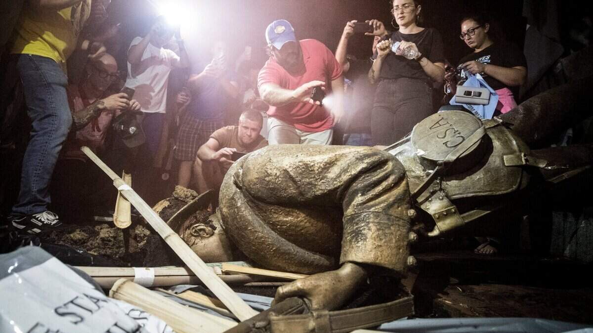 Demonstrators and spectators gather around a toppled Confederate statue known as Silent Sam Monday, August 20, 2018 at UNC-Chapel Hill. Demonstrators surrounded and obscured the statue with large banners before toppling it.
