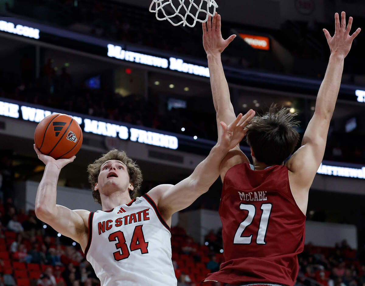N.C. State’s Ben Middlebrooks shoots over Rider’s Cole McCabe during the first half of the Wolfpack’s 89-63 win on Sunday, Dec. 22, 2024, at Lenovo Center in Raleigh, N.C.