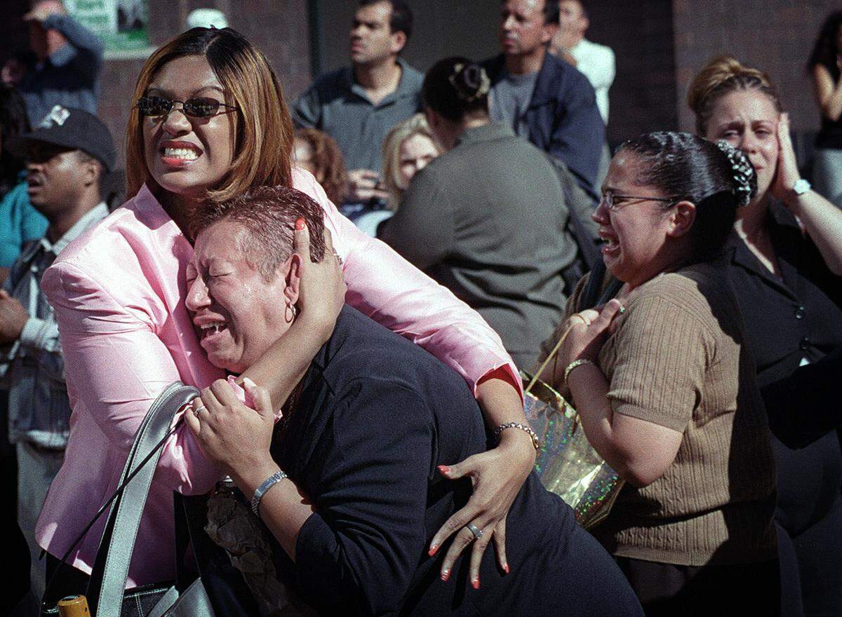 Two women hold each other as they watch the World Trade Center burn in New York Tuesday, Sept. 11, 2001.
