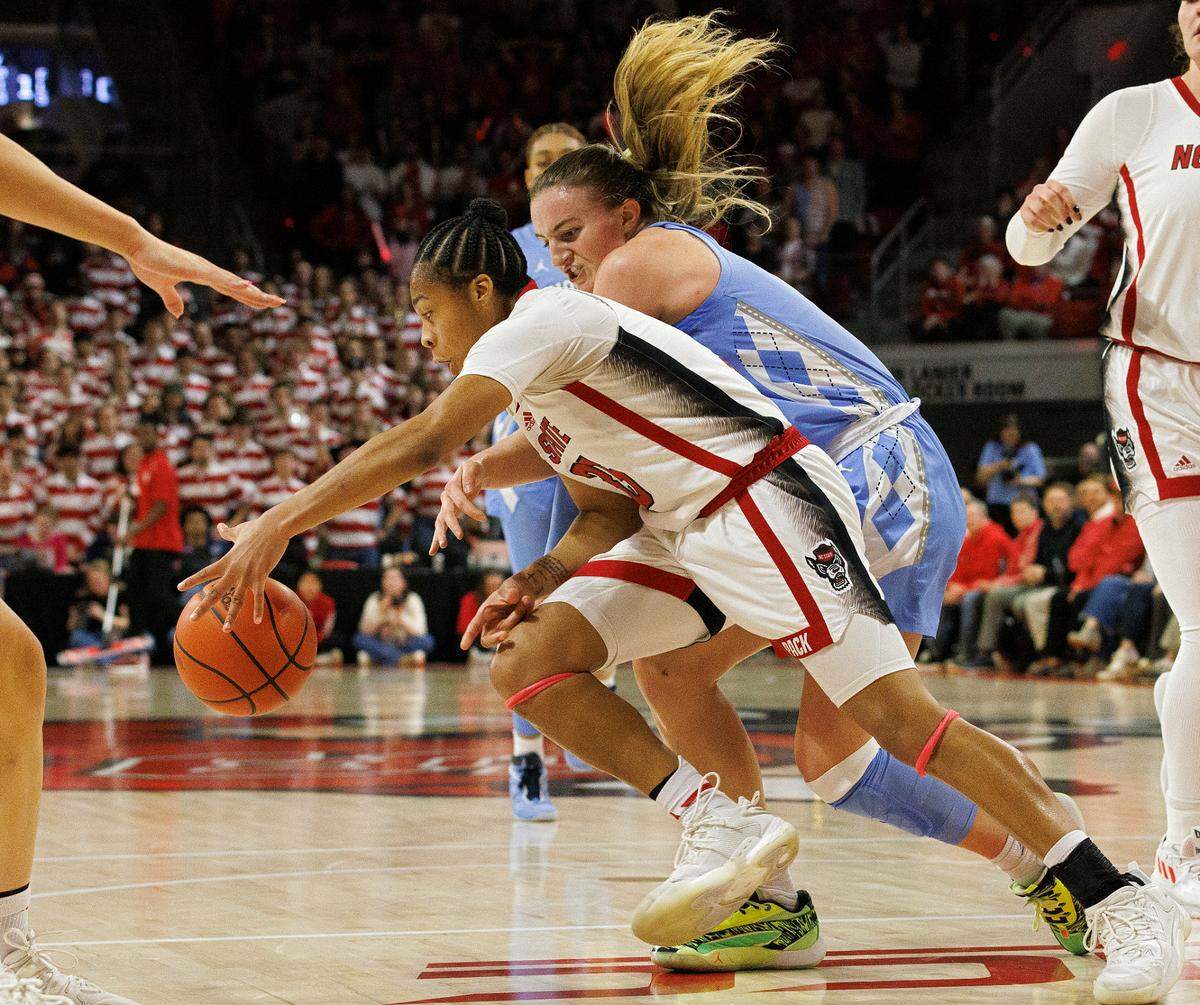 N.C. State’s Zoe Brooks fouls North Carolina’s Alyssa Ustby while chasing after a loose ball during the first half of the Wolfpack’s game on Thursday, Feb. 1, 2024, at Reynolds Coliseum in Raleigh, N.C.