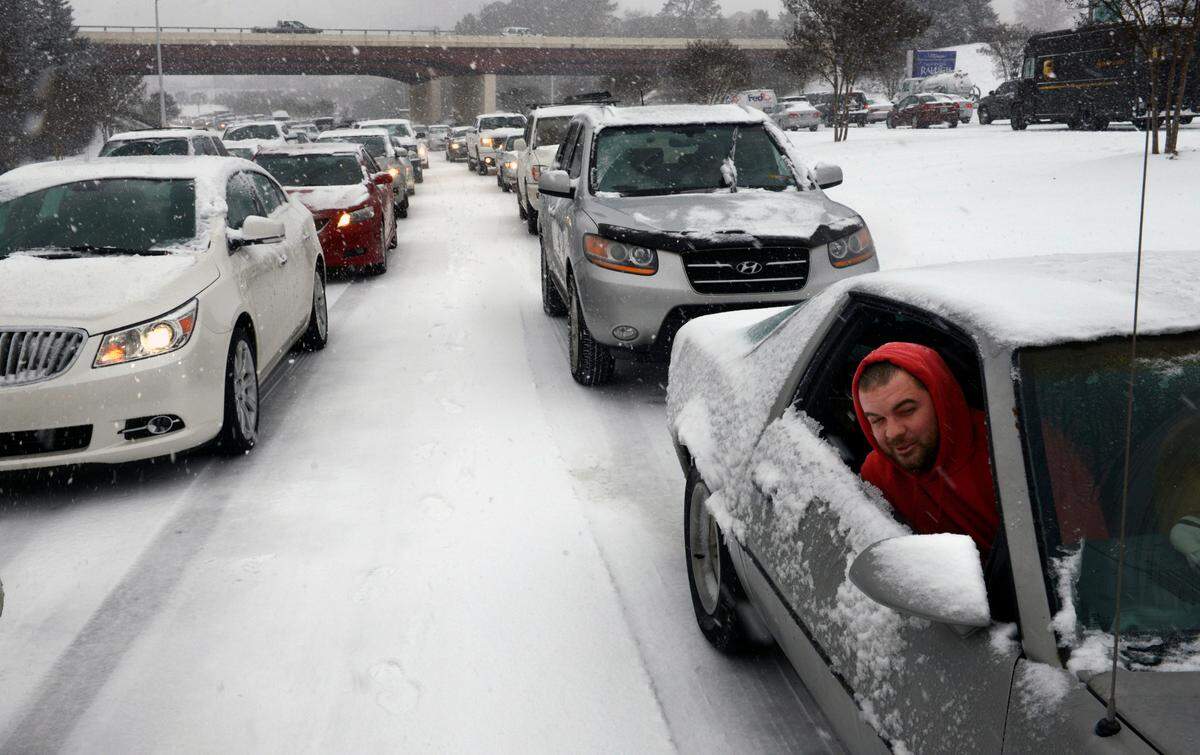 Kevin Miller looks out of the passenger window of his friend’s car as they sit in stuck traffic Wednesday afternoon Feb. 12, 2014 after snow and ice caused massive traffic jams in Raleigh, NC.