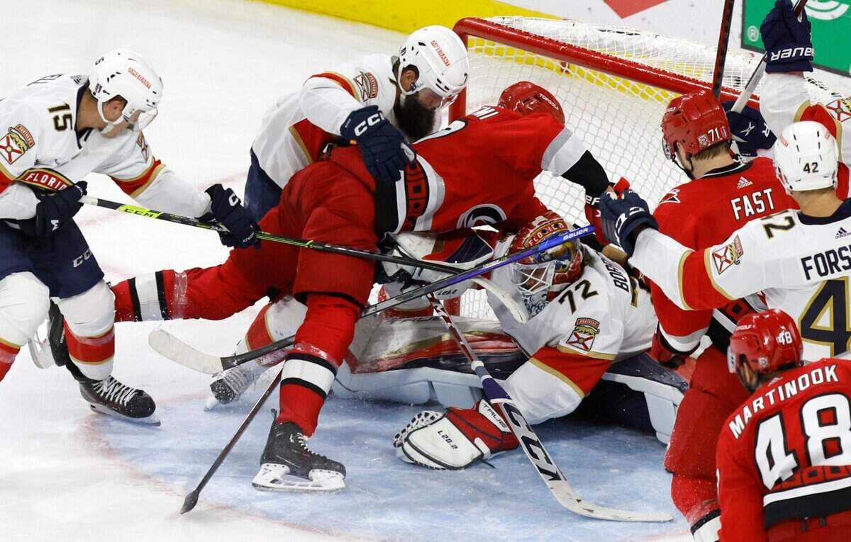 Florida goaltender Sergei Bobrovsky (72) keeps the puck as Carolina center Jesperi Kotkaniemi (82) fall over him during the second period of the Hurricanes’ game against the Panthers in the first game of Eastern Conference Finals at PNC Arena in Raleigh, N.C., on Thursday, May 18, 2023.