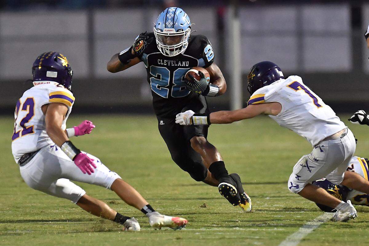 Cleveland’s Omarion Hampton (28) scrambles for yardage against Corinth Holders’ Jacob Alexander (7) and Barak Young (22) during the first quarter. The Cleveland Rams and the Corinth Holders Pirates met in a football game in Clayton, N.C. on September 17, 2021.