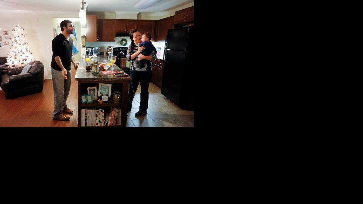 Alan and Areli Josserand play with their 5-month-old baby Andre in their kitchen before dinner on Wednesday in the Water Garden community in Raleigh. Water Garden Village is a 60-unit community that offers apartments for individuals and families with incomes less than 60% of the area median.

