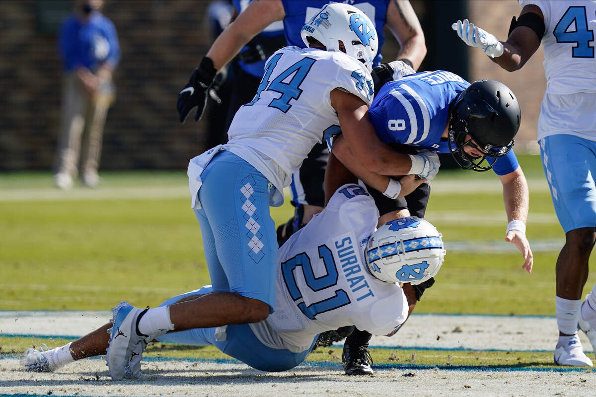 Duke Blue Devils quarterback Chase Brice (8) is tackled by North Carolina Tar Heels linebacker Chazz Surratt (21) during the first quarter at Wallace Wade Stadium.