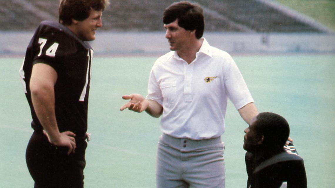 Mack Brown, center, speaks with Appalachian State players Todd Dodson (left) and Terrell Murphy (right). Brown’s first job as a head coach came at App State in 1983.