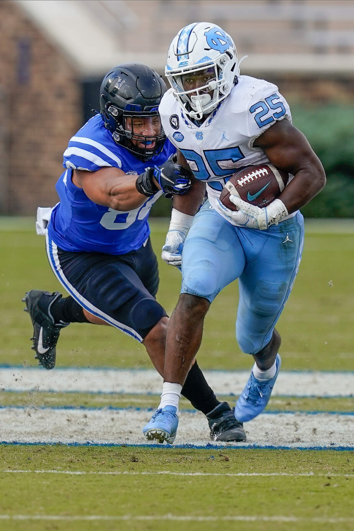 North Carolina Tar Heels running back Javonte Williams (25) runs back a kick off past Duke Blue Devils tight end Jake Marwede (88) during the second half at Wallace Wade Stadium.