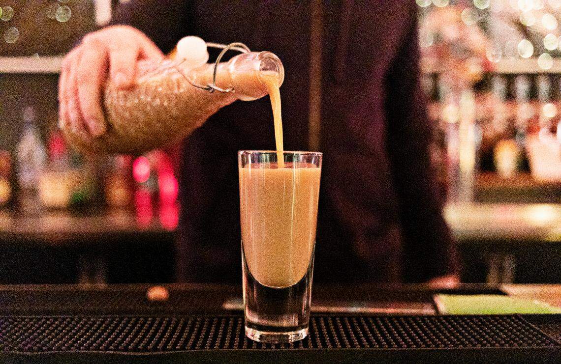 Justin Sykes, beverage director and manager at Jack Tar Restaurant & Lounge in Durham, pours a two-year eggnog at the bar on Monday, Nov, 22, 2021.