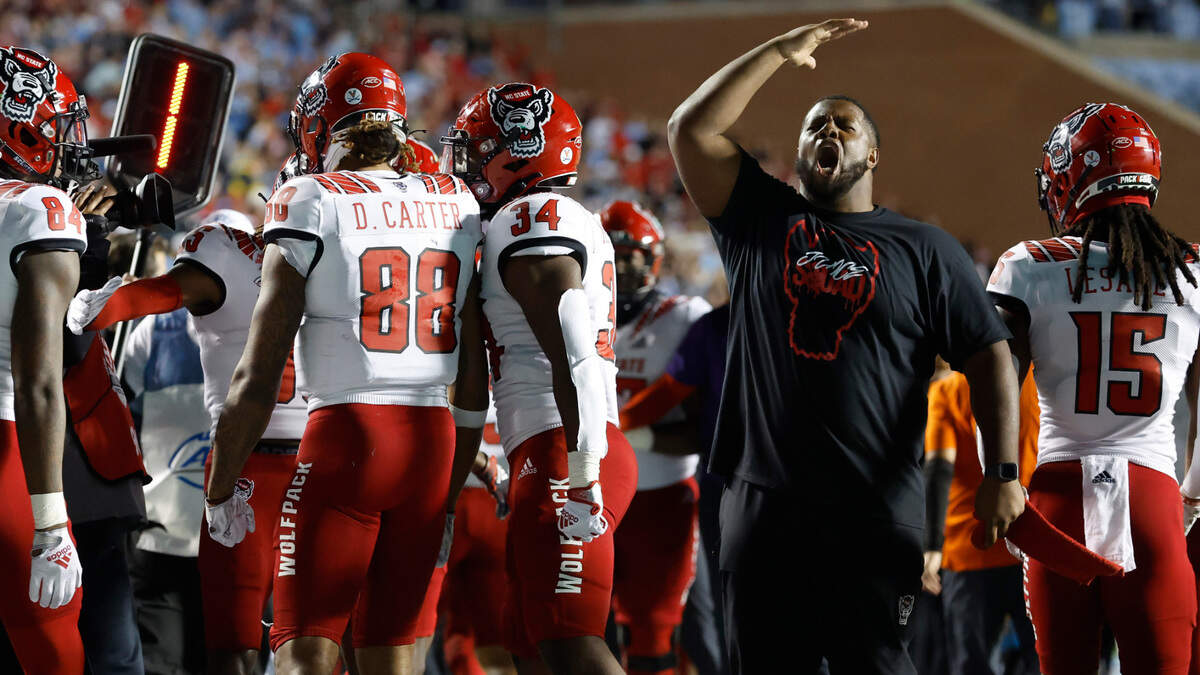 N.C. State’s Grant Gibson, right, celebrates along with teammates after wide receiver Devin Carter (88) made a 26-yard touchdown reception during the second half of N.C. State’s 30-27 overtime victory over UNC at Kenan Stadium in Chapel Hill, N.C., Friday, Nov. 25, 2022.