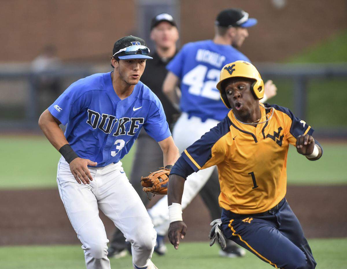 West Virginia’s Tyler Doanes (1) is chased by Duke’s Joey Loperfido (36) before eventually being tagged out during an NCAA college baseball tournament regional game Saturday, June 1, 2019, in Morgantown, W.Va. (William Wotring/The Dominion-Post via AP)