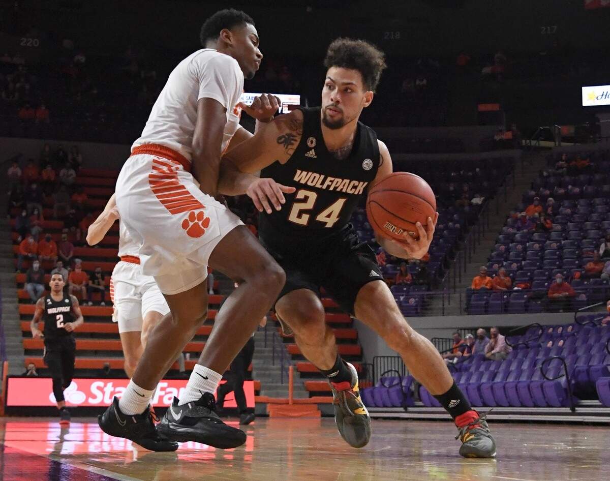NC State guard Devon Daniels(24) dribbles around Clemson senior guard Clyde Trapp (0) during the first half of their game Jan 5, 2021.
