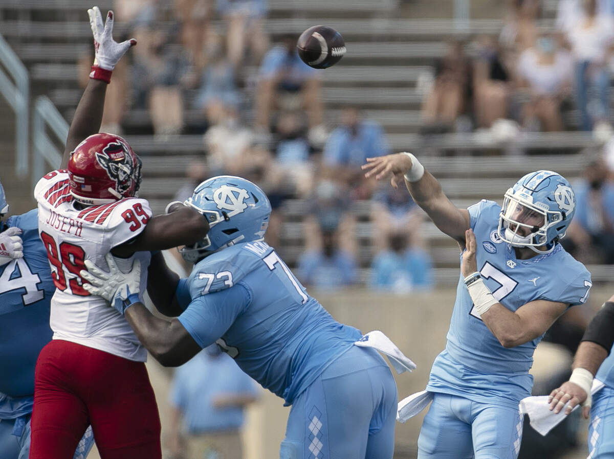 North Carolina quarterback Sam Howell (7) passes over N.C. State’s Daniel Joseph (99) in the second quarter at Kenan Stadium on Saturday, October 24, 2020 in Chapel Hill, N.C.