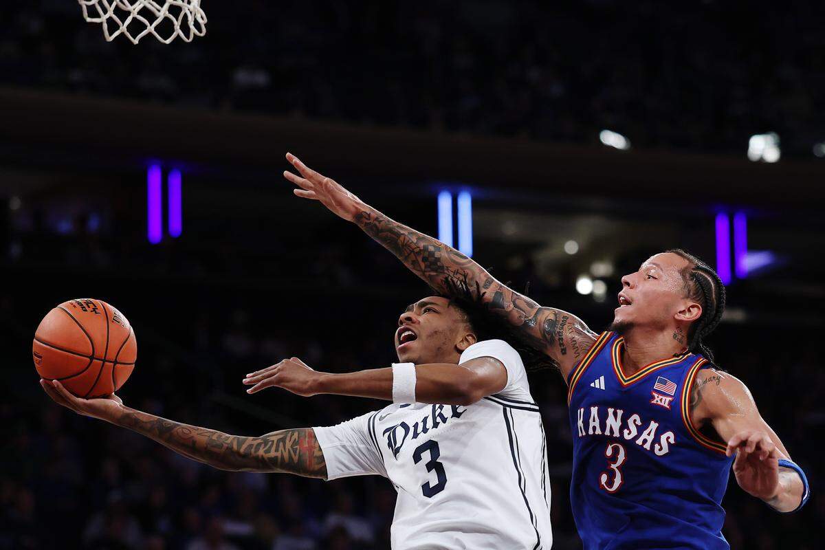 Duke’s Isaiah Evans (3) goes to the basket as Kansas’ Tre White (3) during the first half of the Champions Classic at Madison Square Garden on November 18, 2025 in New York City.